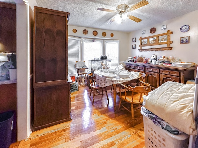 dining space featuring ceiling fan, light hardwood / wood-style floors, and a textured ceiling