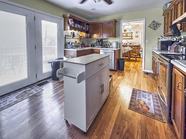 kitchen featuring ceiling fan, a center island, stainless steel appliances, and light hardwood / wood-style flooring