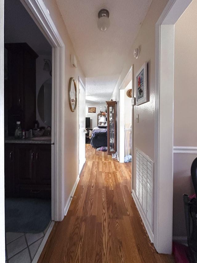 hallway featuring hardwood / wood-style floors and sink