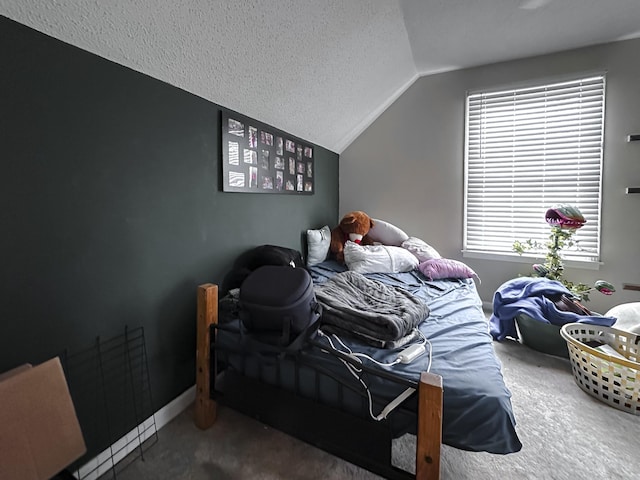 carpeted bedroom featuring a textured ceiling and vaulted ceiling