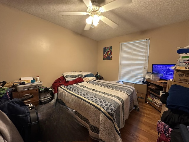 bedroom featuring hardwood / wood-style floors, a textured ceiling, and ceiling fan