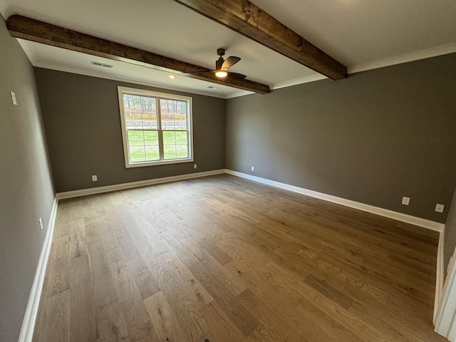 spare room featuring beam ceiling, ceiling fan, crown molding, and wood-type flooring