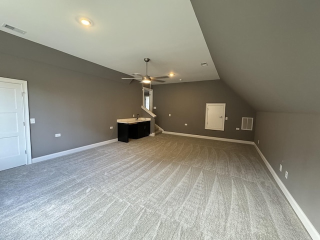 unfurnished living room featuring lofted ceiling, ceiling fan, and carpet floors