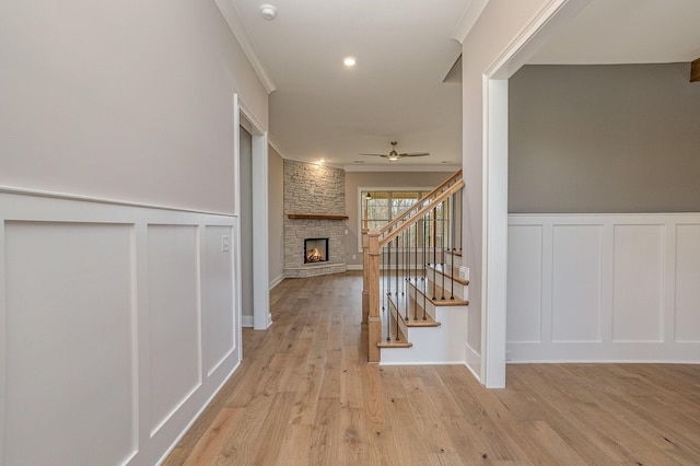 hallway with light wood-type flooring and crown molding