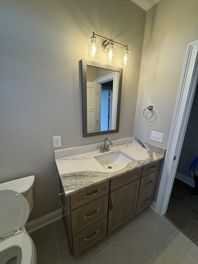 bathroom with tile patterned flooring, vanity, and toilet