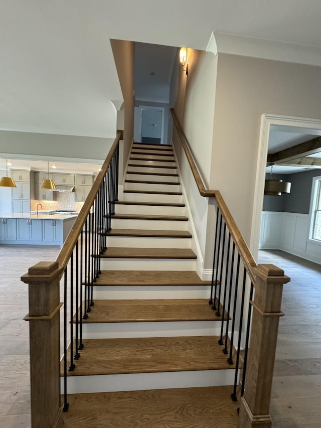 staircase featuring hardwood / wood-style flooring and sink