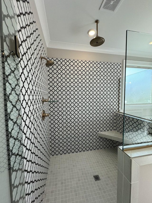 interior details featuring tiled shower and ornamental molding