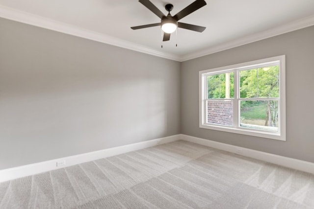 spare room featuring light colored carpet, ceiling fan, and ornamental molding