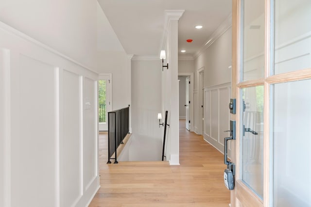 hall featuring ornamental molding and light hardwood / wood-style flooring