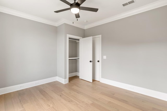 unfurnished bedroom featuring light wood-type flooring, a closet, ceiling fan, and crown molding