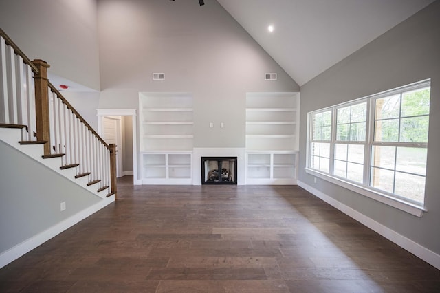 unfurnished living room with dark hardwood / wood-style flooring and high vaulted ceiling