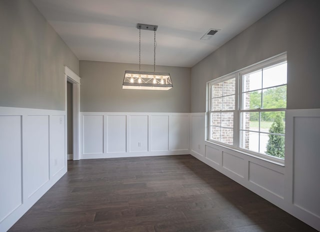 unfurnished dining area with dark wood-type flooring