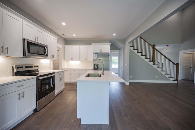 kitchen with white cabinetry, sink, dark hardwood / wood-style flooring, a center island with sink, and appliances with stainless steel finishes