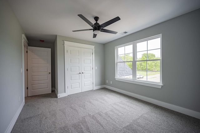 unfurnished bedroom with carpet flooring, ceiling fan, and a closet