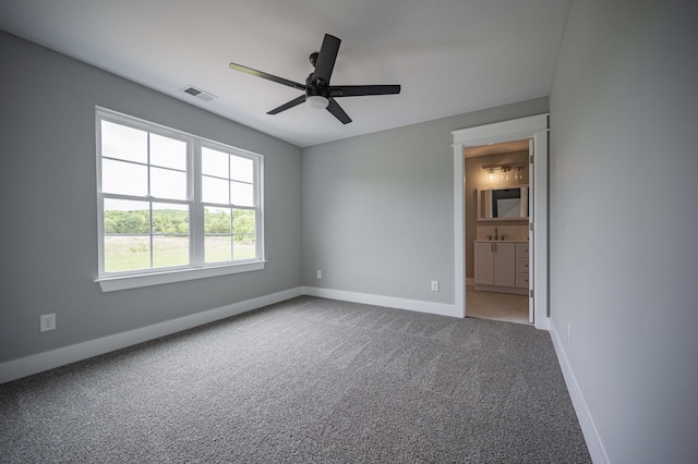 unfurnished bedroom featuring carpet flooring, ceiling fan, and connected bathroom