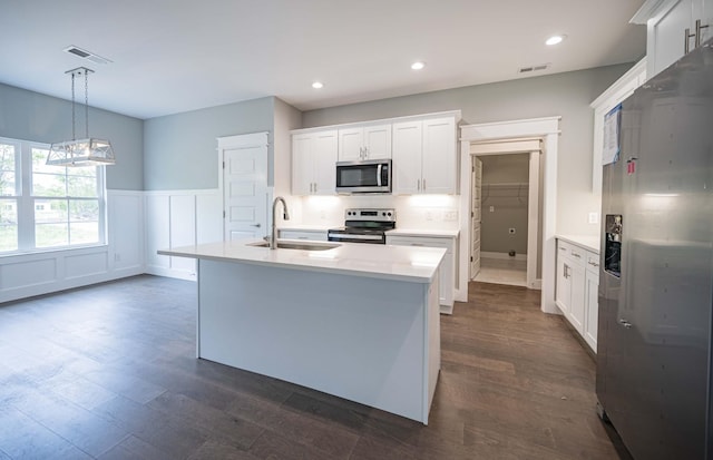 kitchen with pendant lighting, white cabinets, sink, dark hardwood / wood-style flooring, and stainless steel appliances