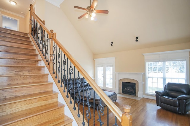 stairs with ceiling fan, french doors, wood-type flooring, a fireplace, and ornamental molding