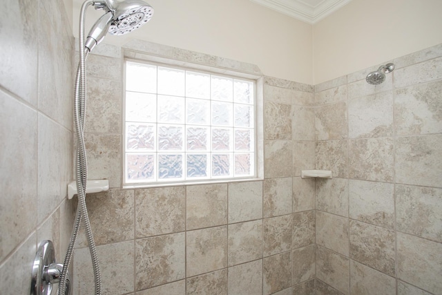 interior details featuring tiled shower and crown molding