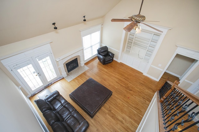 living room with hardwood / wood-style floors, ceiling fan, a fireplace, and vaulted ceiling