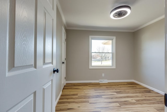 unfurnished room with light hardwood / wood-style floors and crown molding