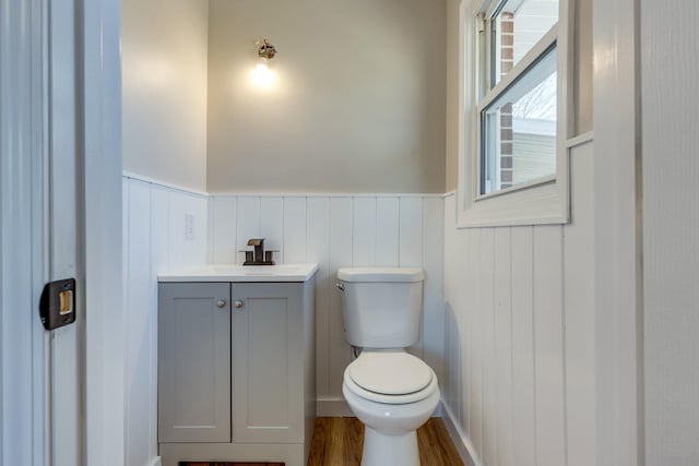 bathroom with hardwood / wood-style floors, toilet, and vanity