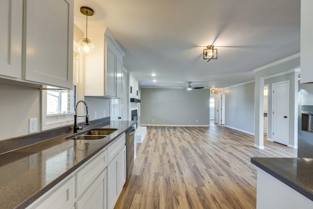 kitchen featuring hanging light fixtures, white cabinets, sink, and dark stone countertops