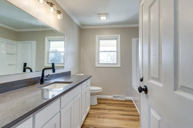 bathroom with vanity, a wealth of natural light, ornamental molding, and hardwood / wood-style flooring