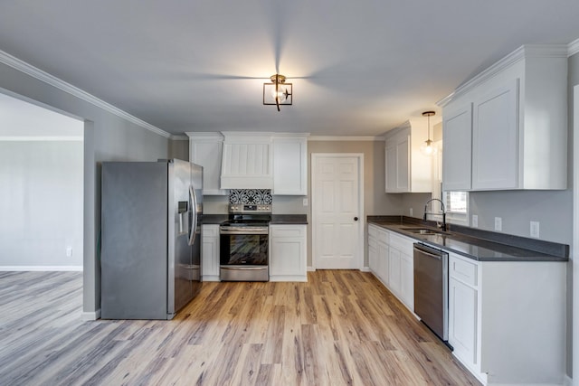 kitchen with pendant lighting, sink, white cabinetry, and appliances with stainless steel finishes