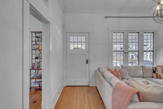 foyer with wood-type flooring, crown molding, and a notable chandelier