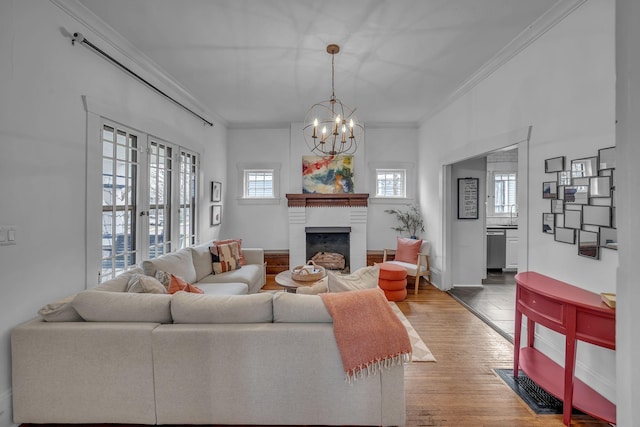 living room with hardwood / wood-style floors, an inviting chandelier, and ornamental molding