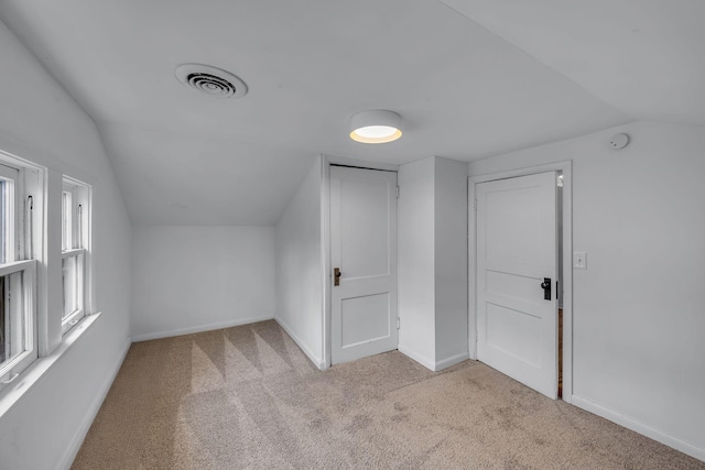 additional living space featuring light carpet and lofted ceiling