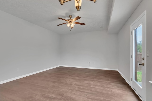 unfurnished room with hardwood / wood-style flooring, ceiling fan, and a textured ceiling