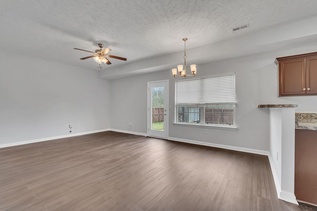 interior space featuring a textured ceiling, ceiling fan with notable chandelier, and dark wood-type flooring