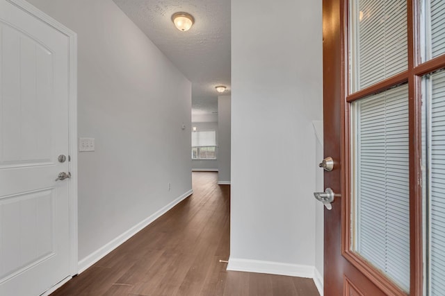 entryway with dark wood-type flooring and a textured ceiling