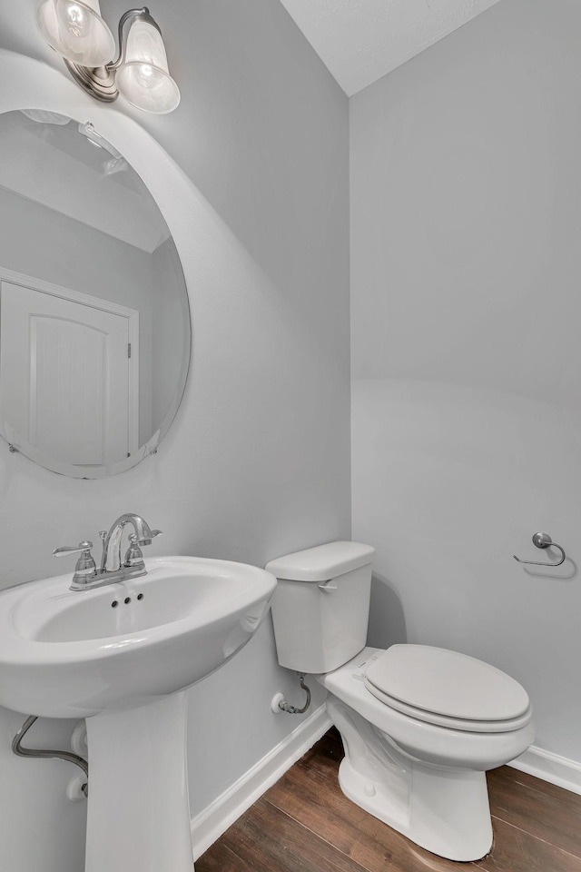 bathroom with wood-type flooring and toilet