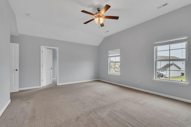 empty room featuring ceiling fan, light carpet, and vaulted ceiling