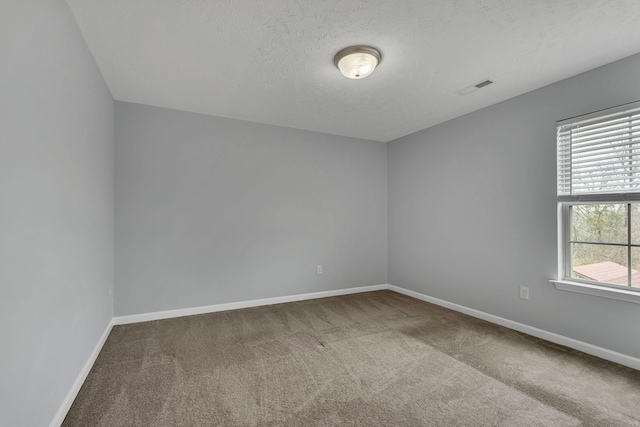 carpeted spare room featuring a textured ceiling