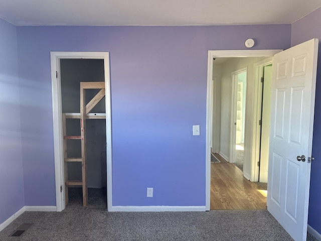 unfurnished bedroom with a closet and carpet floors