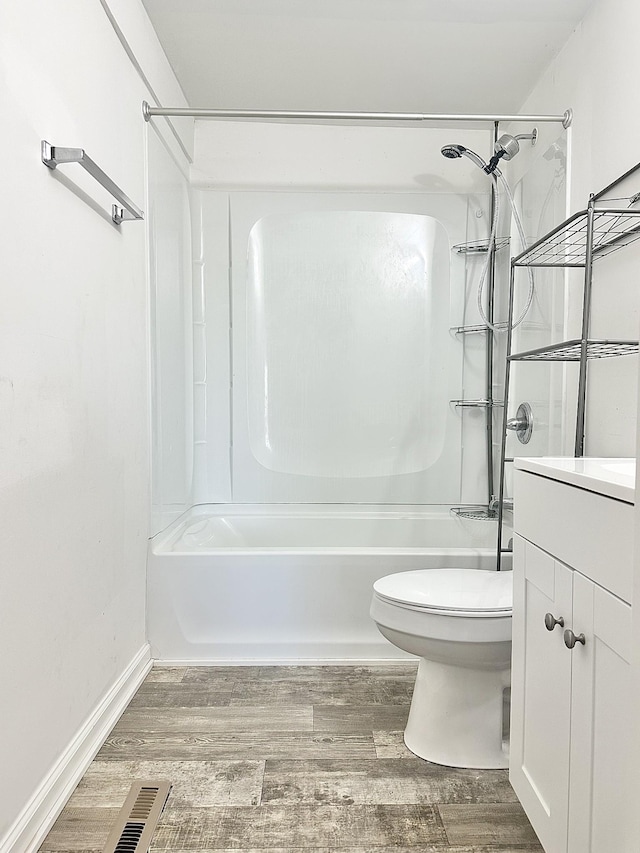 full bathroom featuring washtub / shower combination, vanity, hardwood / wood-style flooring, and toilet