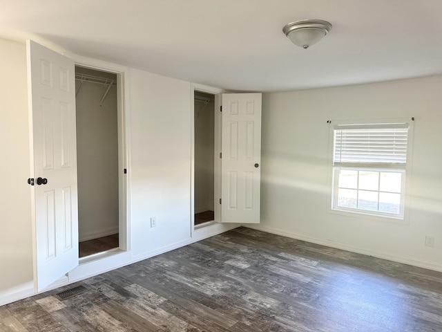 unfurnished bedroom with a closet and dark wood-type flooring