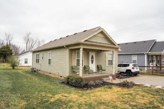 view of front of home with cooling unit, a porch, and a front lawn