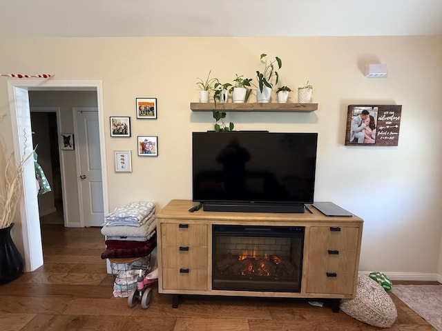living area featuring baseboards and dark wood-style flooring