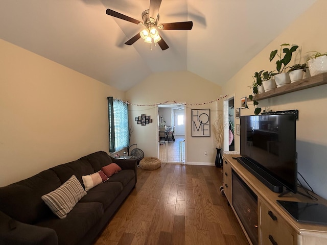 living room featuring lofted ceiling, ceiling fan, baseboards, and wood finished floors