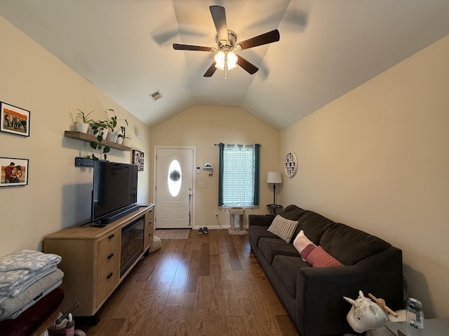 living area with baseboards, visible vents, a ceiling fan, dark wood-style flooring, and vaulted ceiling