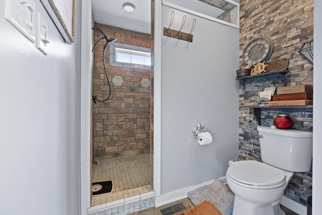 bathroom with tiled shower and toilet