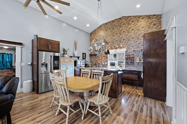 dining area with high vaulted ceiling, light hardwood / wood-style flooring, and ceiling fan