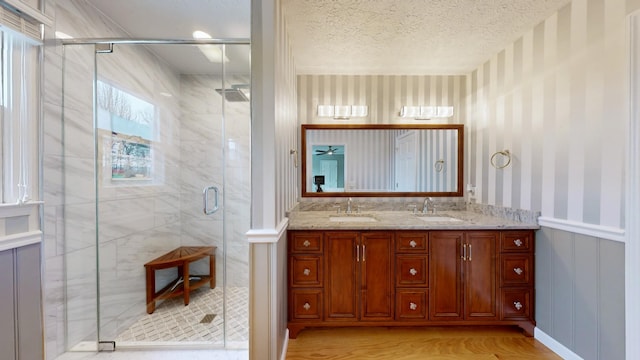 bathroom with a shower with door, vanity, a textured ceiling, and wood-type flooring