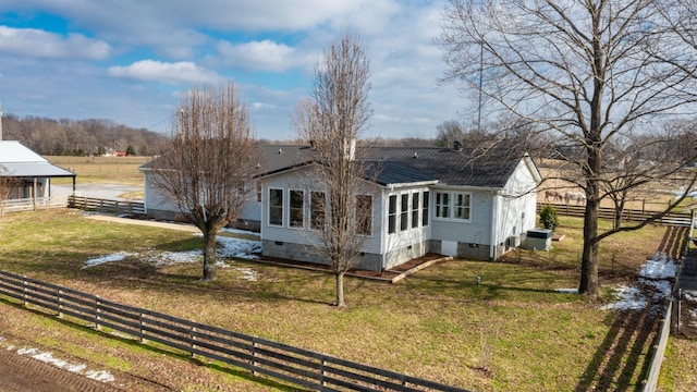 back of property featuring central air condition unit and a lawn