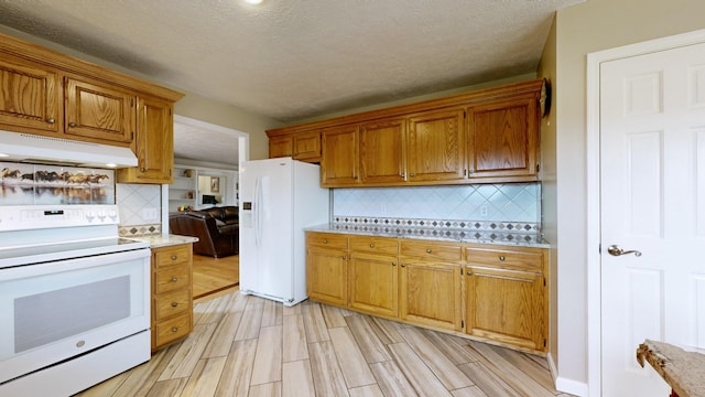 kitchen with white appliances, a textured ceiling, light hardwood / wood-style floors, and backsplash