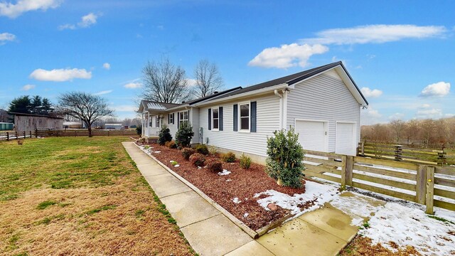 view of side of property with a yard and a garage